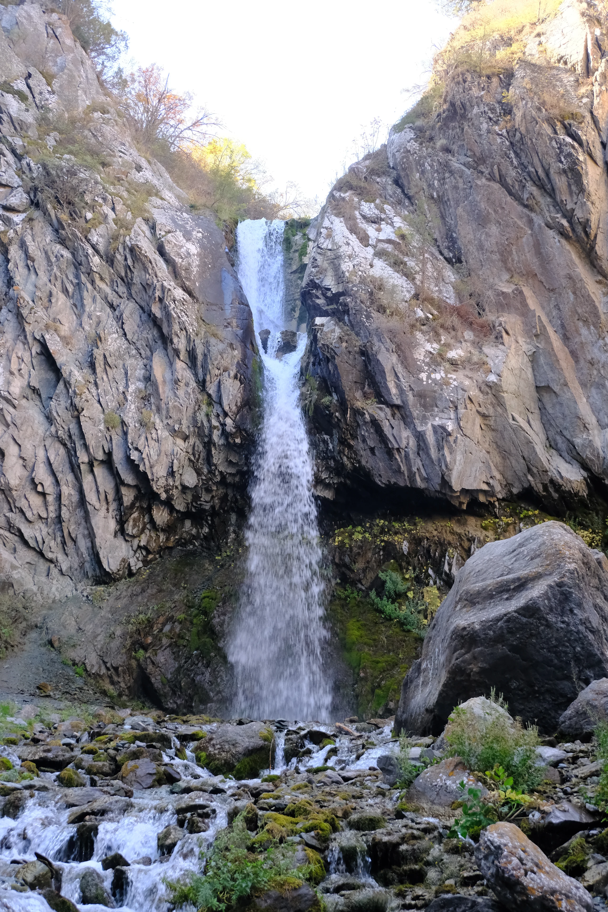 A waterfall cascading between rocky walls in Alamedin Ravine.
