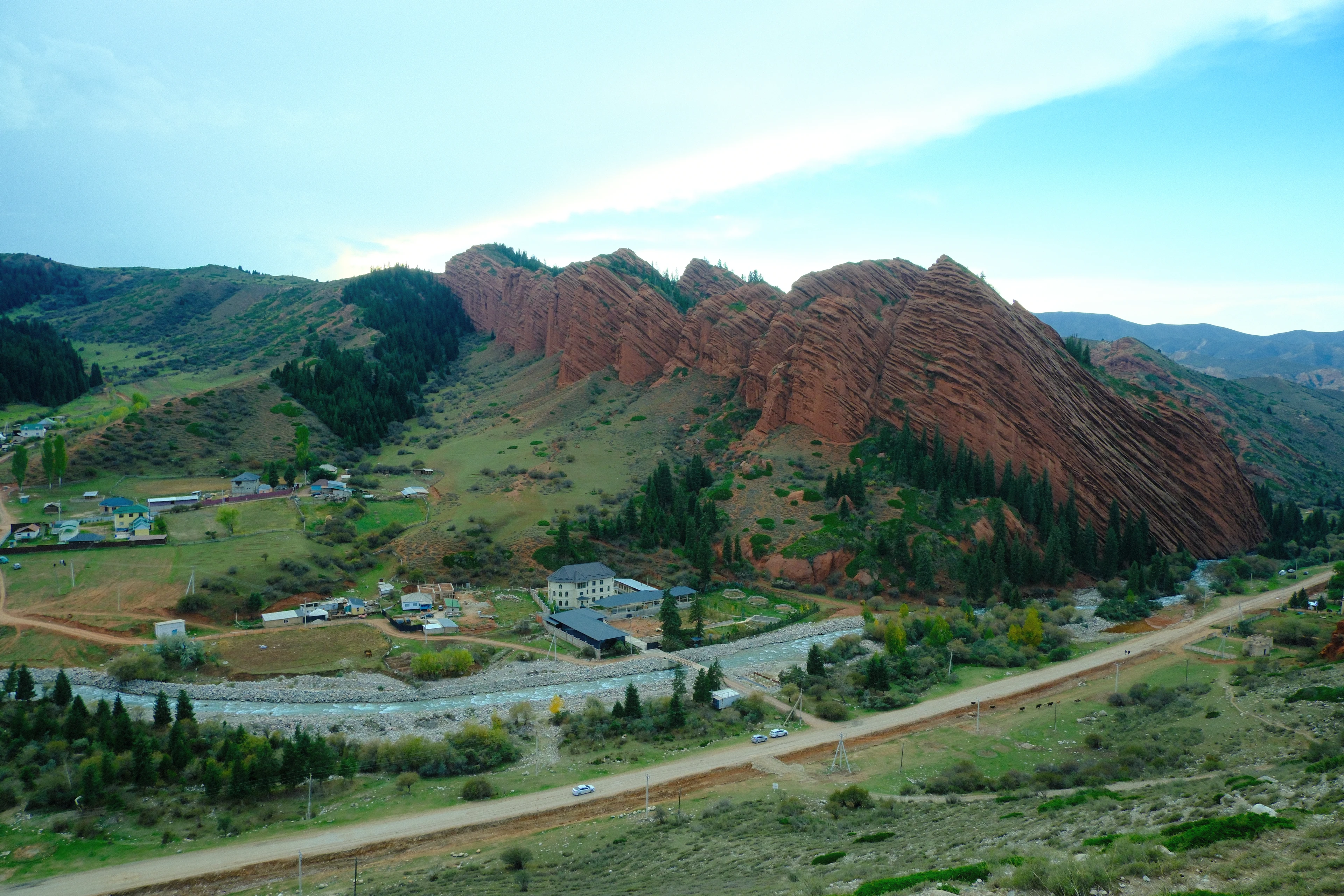 Red sandstone cliffs above the river and village at Jeti-Oguz.
