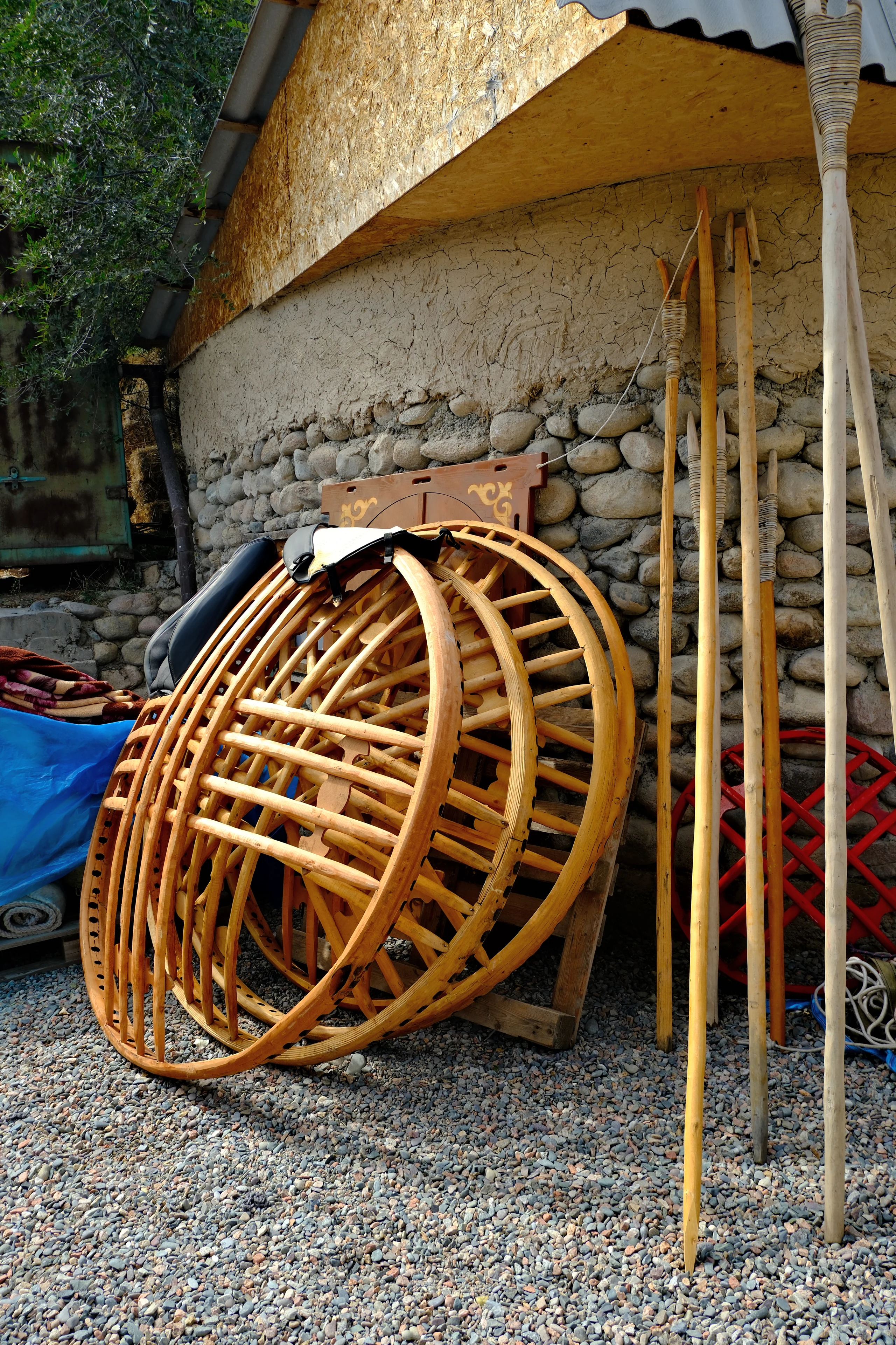 Wooden tunduk roof rings and poles used to assemble a traditional Kyrgyz yurt.