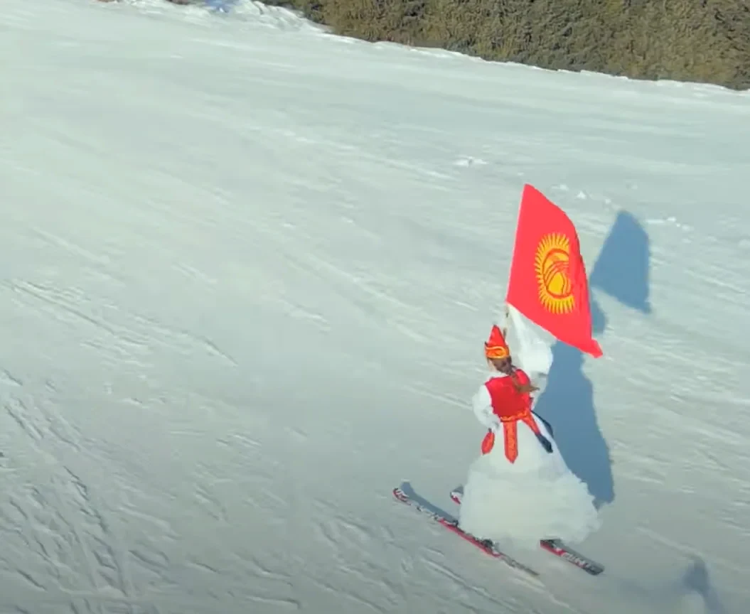 Diana Voit skiing with the Kyrgyz flag at Karakol ski base.