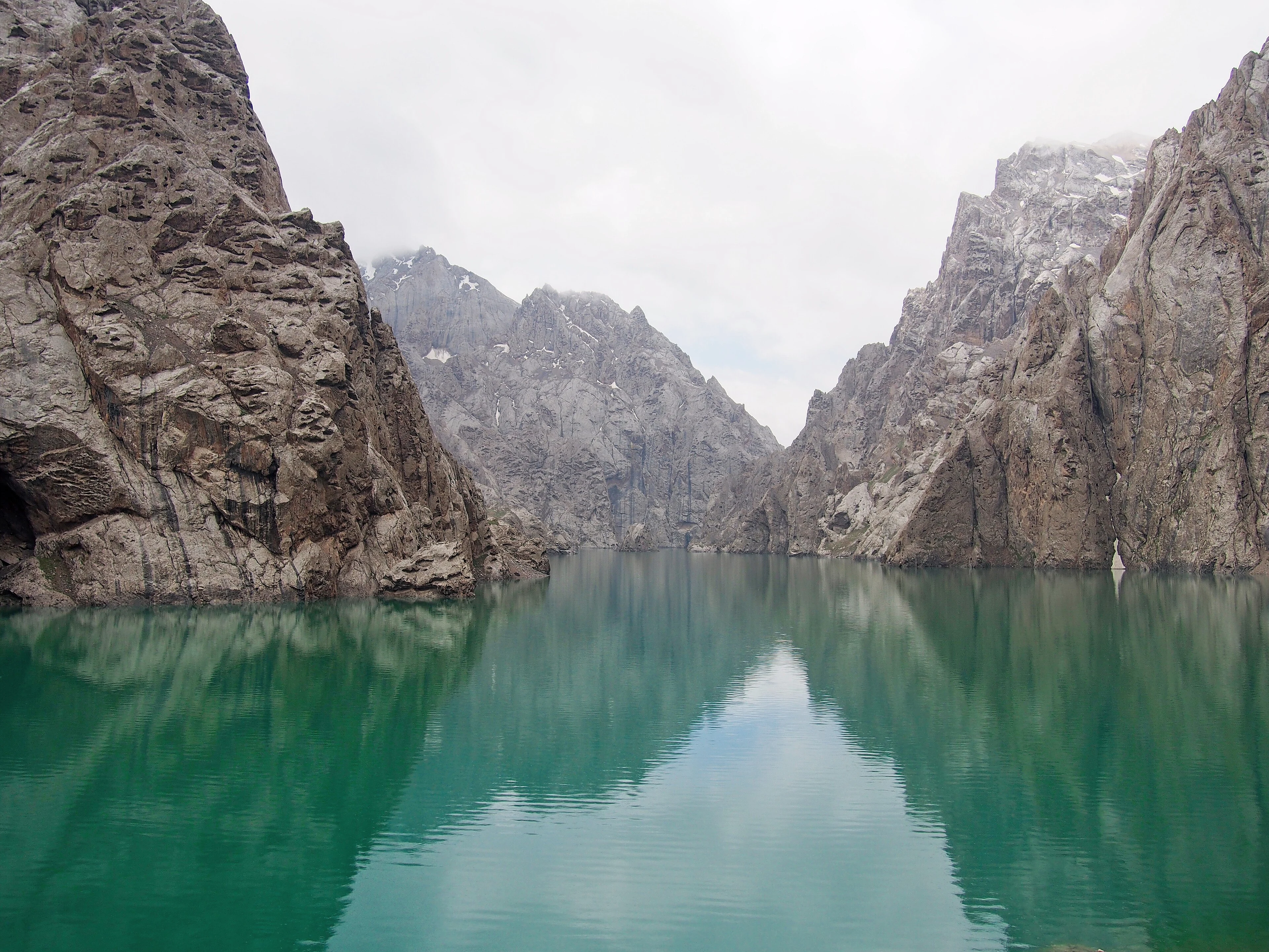 Kel-Suu lake enclosed by steep limestone cliffs.