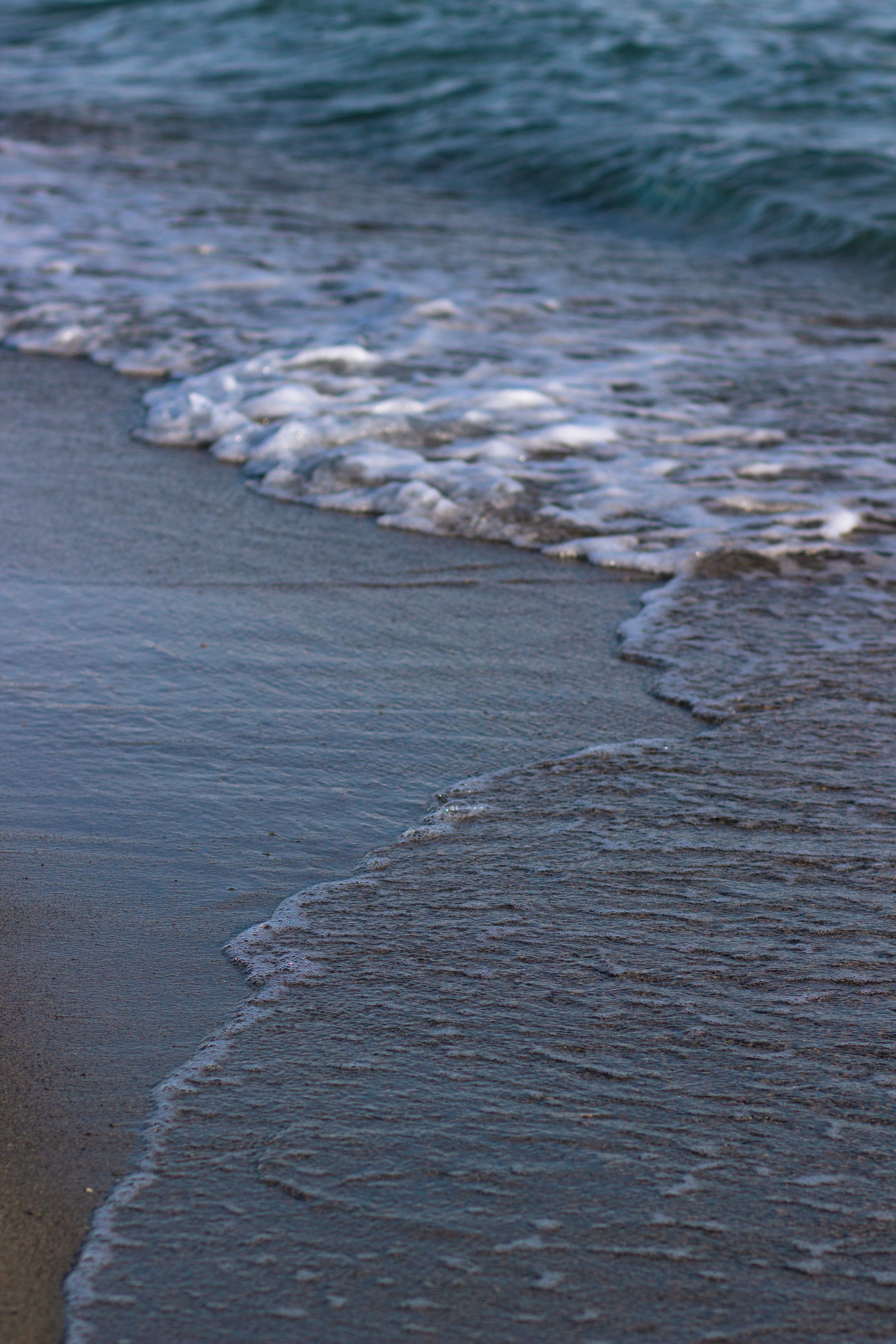 Gentle waves break along the sandy shore of Issyk-Kul.