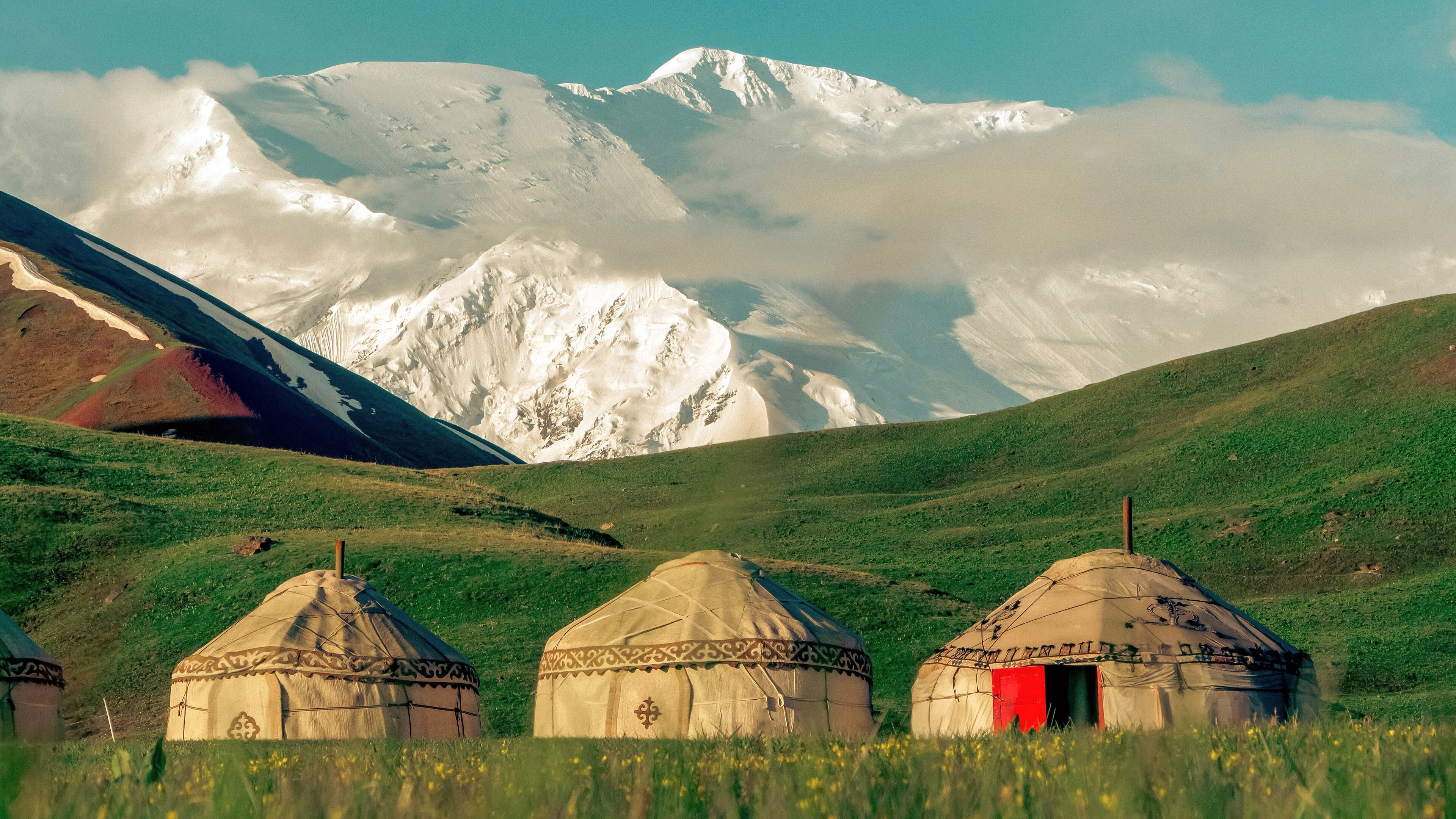 Yurts in the Sary-Mogol area beneath the snow-covered Pamir mountains.