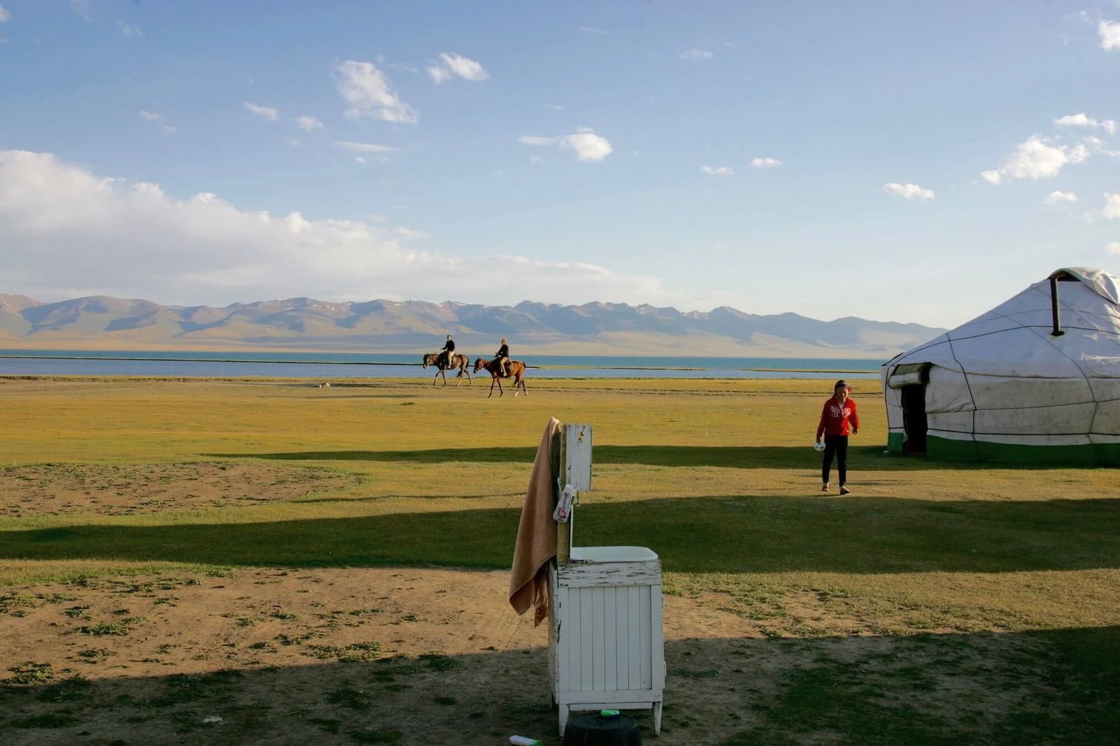 Yurts, riders and summer grassland beside Song-Kul lake.